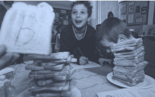 Students performing experiments with stacks of toast, one piece marked with a large "B".