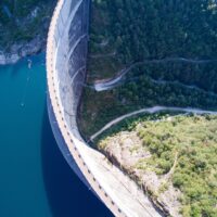 Aerial view of a large dam surrounded by water and forest.